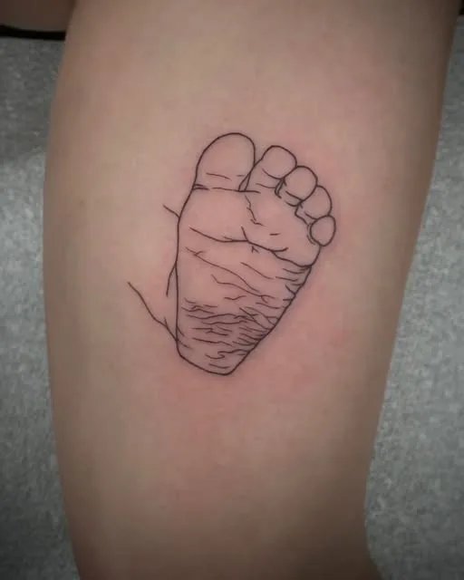 Baby footprint fine-line tattoo