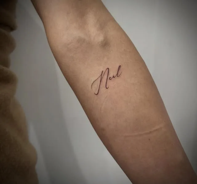 Custom script name lettering tattoo
